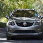 2020 Buick Envision exterior front fascia on shaded road with trees