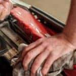 Mechanic using the dipstick to check the oil in a car engine