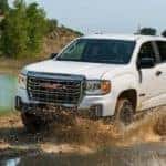 2021-GMC-Canyon-AT4-Off-Road-Performance-Edition-Exterior-Driver-Side-Front-Profile-in-Muddy-Water_o