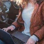 GMC Work From Anywhere Week Woman Holding Laptop in Driver Seat