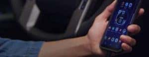 a hand holding a phone in a car