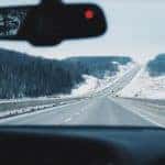 a vehicle driving on a wintery road