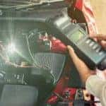 a person holding a device by a vehicle