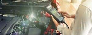 a person holding a device by a vehicle