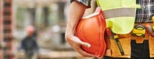 a person holding an orange hard hat