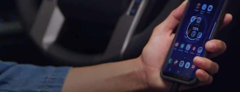 a hand holding a cellphone in a vehicle
