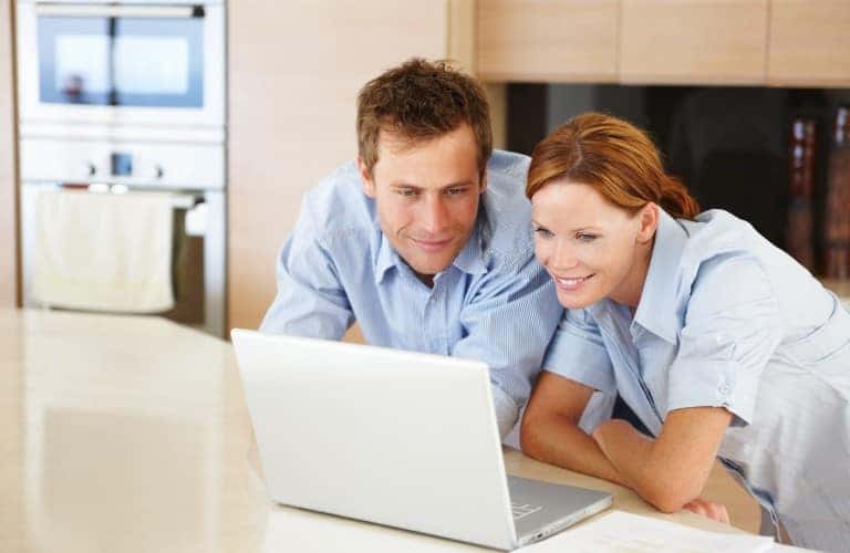 two people using a laptop together in a house