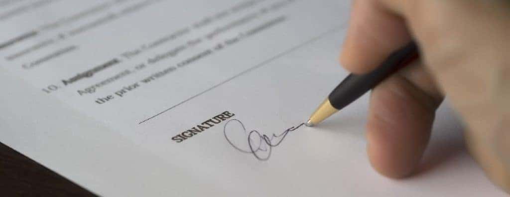 a hand signing a document close up