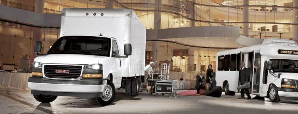 2023 GMC box van next to a GMC bus by a hotel