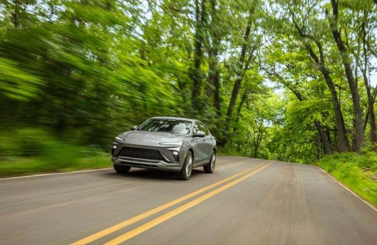2024 Buick Envista driving on a road through a forest