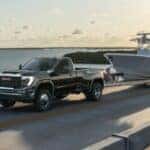 2024 GMC Sierra HD towing a boat on a bridge