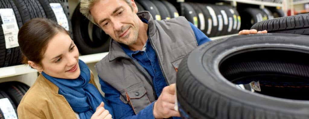 two people inspecting a car tire together