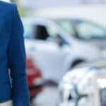 a person holding a car key at a dealership