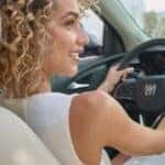a woman in the driver's seat of a Buick vehicle