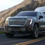 2025 GMC Sierra EV Denali towing a trailer on a mountain