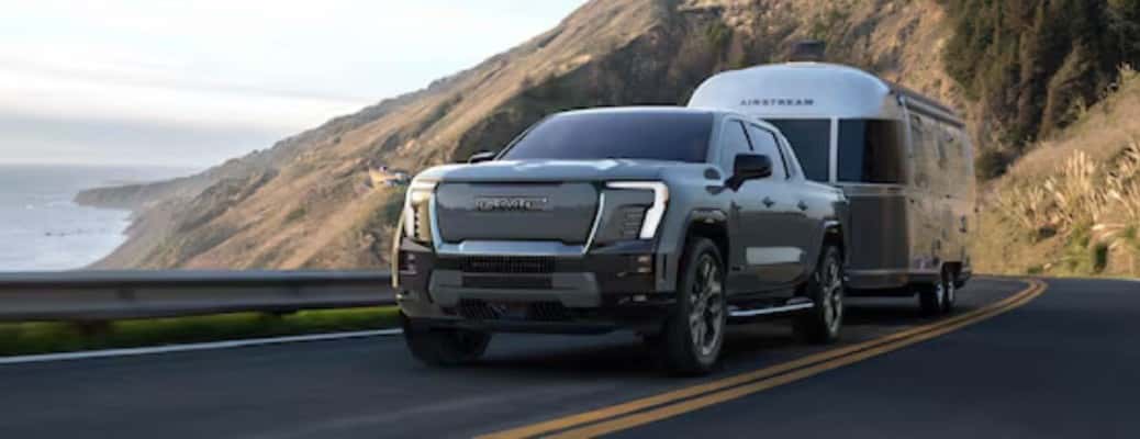 2025 GMC Sierra EV Denali towing a trailer on a mountain