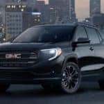 A black 2019 GMC Terrain with a city in the background at night