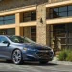 2019 Chevy Malibu parked in front of a modern building downtown