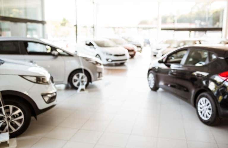 A variety of vehicles inside of a dealership's showroom