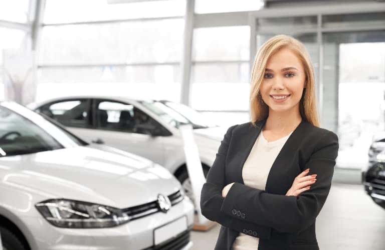 Woman standing in front of vehicles in a showroom