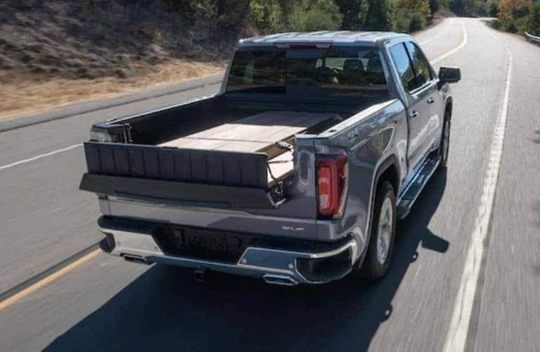 2021 GMC Sierra 1500 driving away with items in the bed of the truck