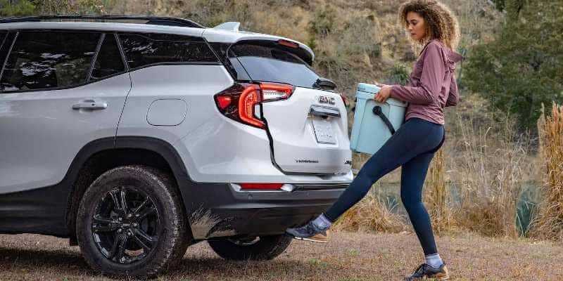 A woman operating the optional powered liftgate on the GMC Terrain.