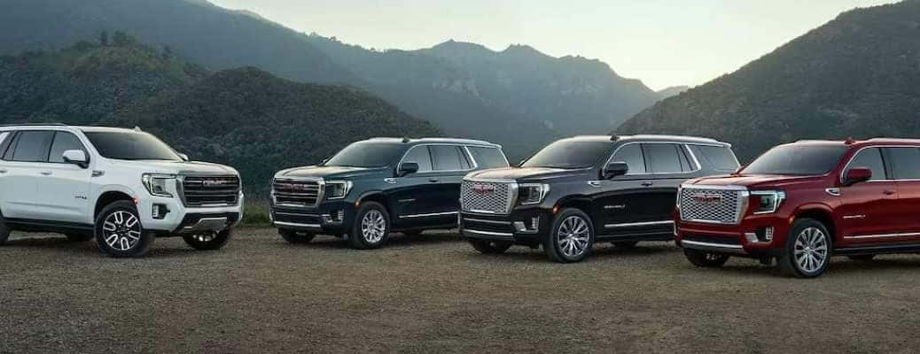 A collection of different colored 2023 GMC Yukons, which have excellent cargo and passenger capacity.