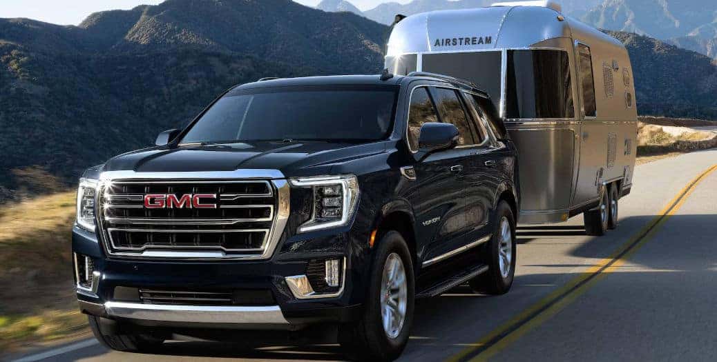 The 2023 GMC Yukon XL towing a camper.