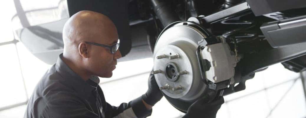 Fall Auto Maintenance Tips include checking your brakes, like this technician is doing.