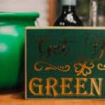 A St. Patrick's Day sign near some mugs and a pot of gold.