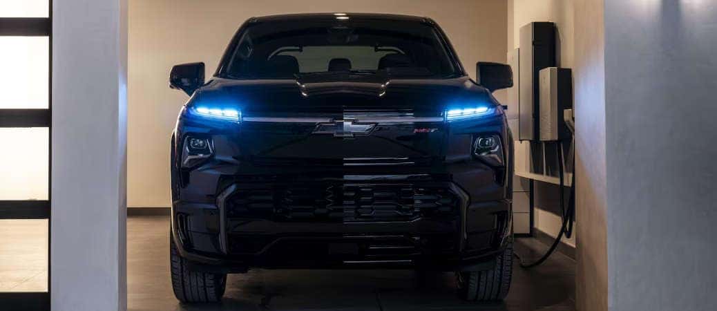 A front view of the 2025 Chevy Silverado EV at a wall charger.