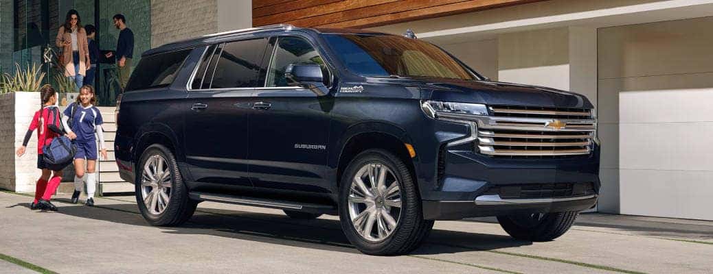 An exterior shot of a family with there 2025 Chevy Suburban equipped with Chevy Safety Assist.