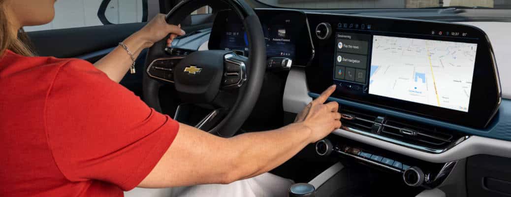 A woman using a Chevy infotainment system with Google built-in.