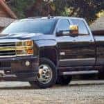 Black 2019 Chevy Silverado HD in front of log cabin