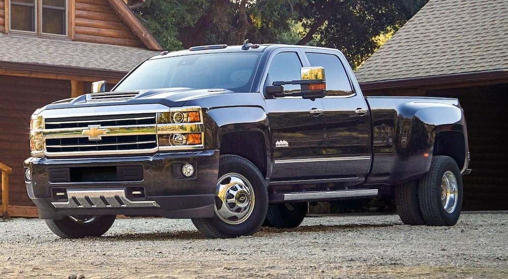 Black 2019 Chevy Silverado HD in front of log cabin