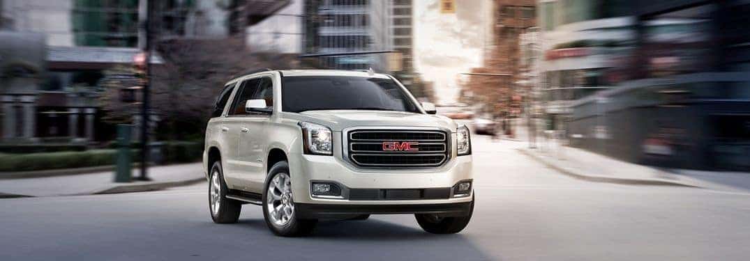front view of white 2019 GMC Yukon driving through city streets