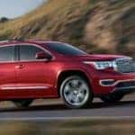 Red 2019 GMC Acadia driving on mountain