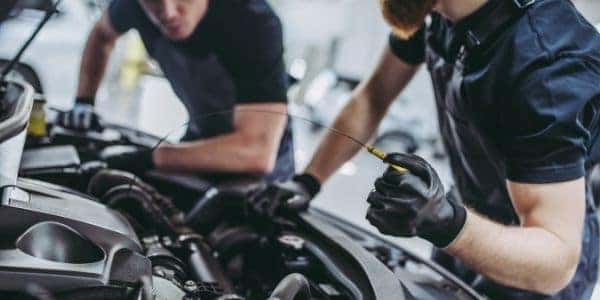 Closeup of two auto mechanics checking vehicle