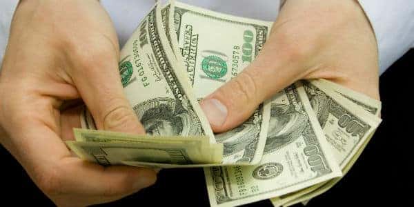 Closeup of hands counting $100 bills