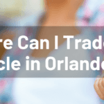 Hand holding out vehicle key with "Where Can I Trade in a Vehicle in Orlando FL?" white overlay text