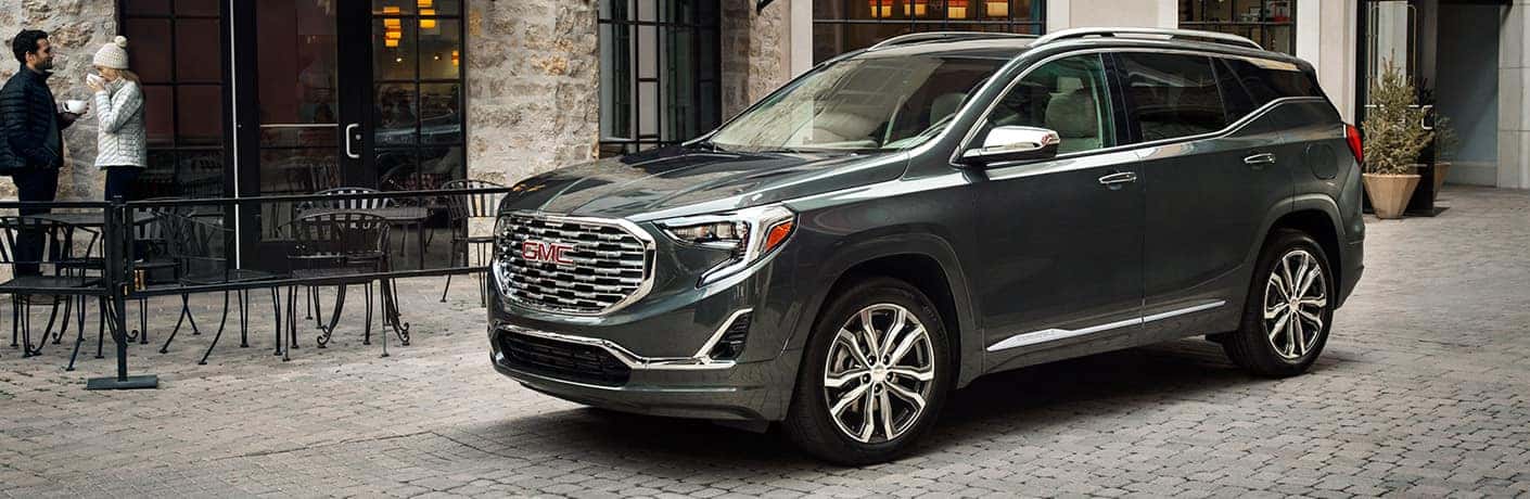 2019 GMC Terrain Denali parked on a cobblestone street in front of a coffee shop.