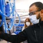 Man in a GM uniform looks at ventilators
