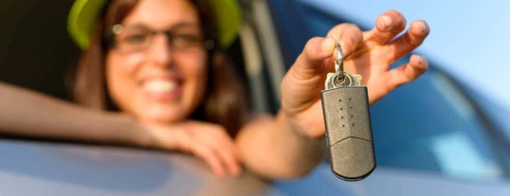 a woman in a car holding car keys