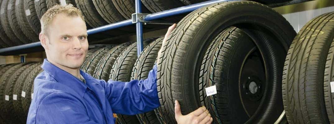 a man in a blue shirt holding a tire
