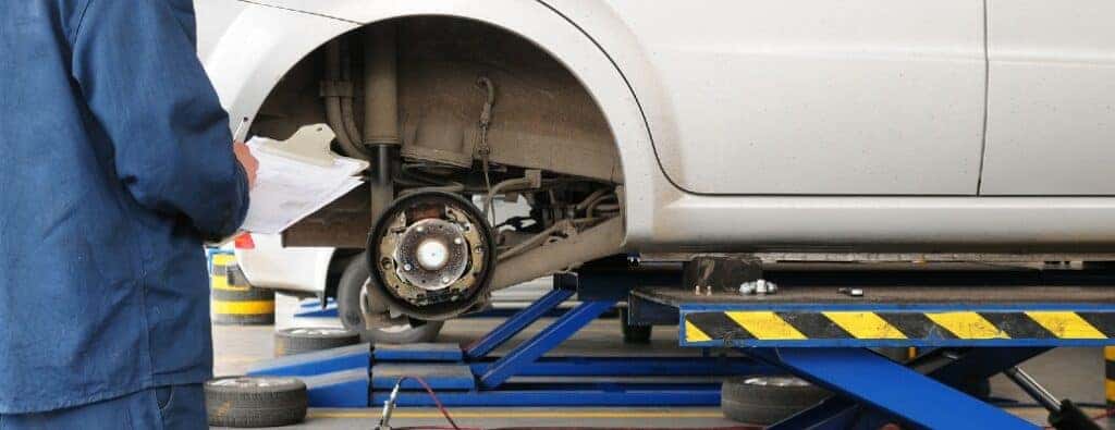 a technician inspecting a vehicles brakes