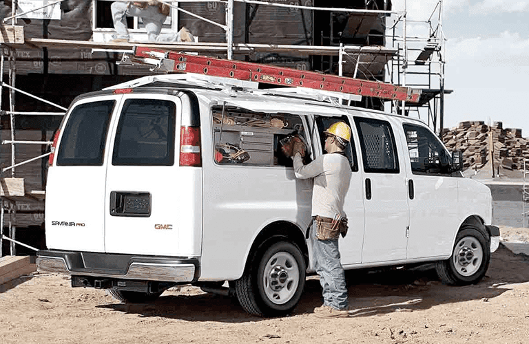 2023 GMC Savana van at a work site with a worker