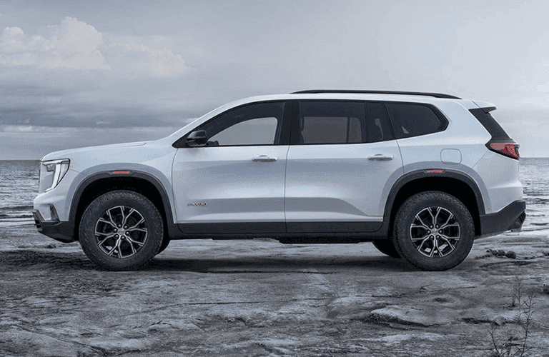 2024 GMC Acadia side view parked on rocks
