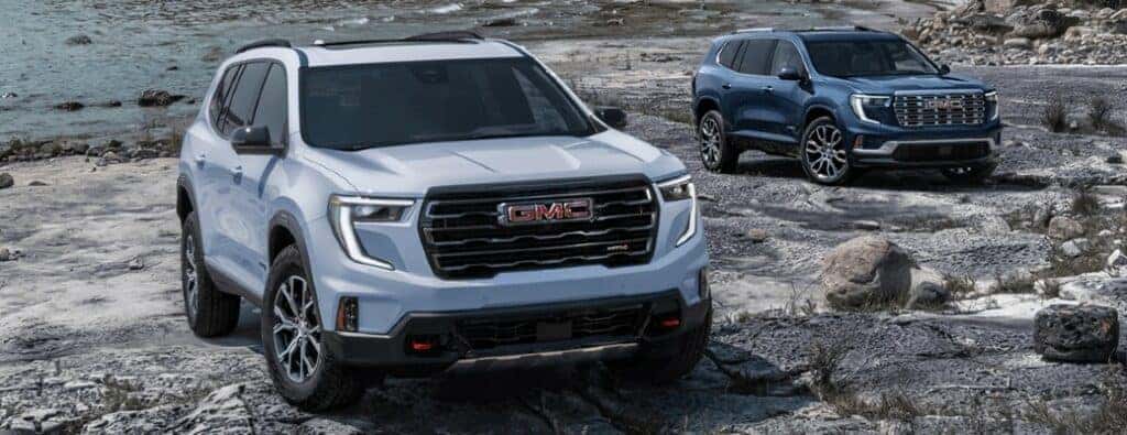 2024 GMC Acadia models driving over a rocky surface