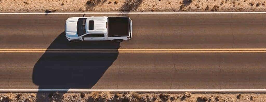 a white GMC truck driving on a road overhead view