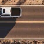 a white GMC truck driving on a road overhead view